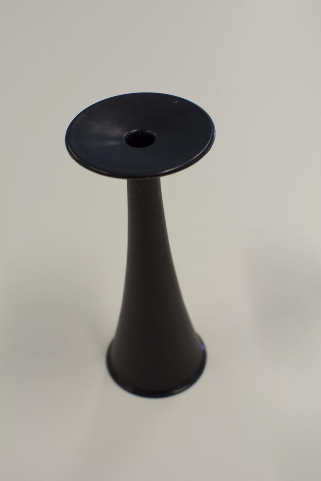 Instrumento negro con forma de campana a cuyo extremo estrecho se adosa un disco con una oquedad interior. 