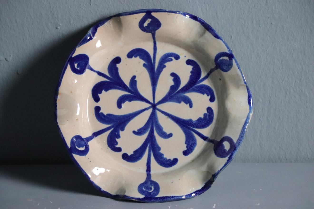 Cenicero de cerámica granadina con decoración vegetal y geométrica azul sobre fondo blanco