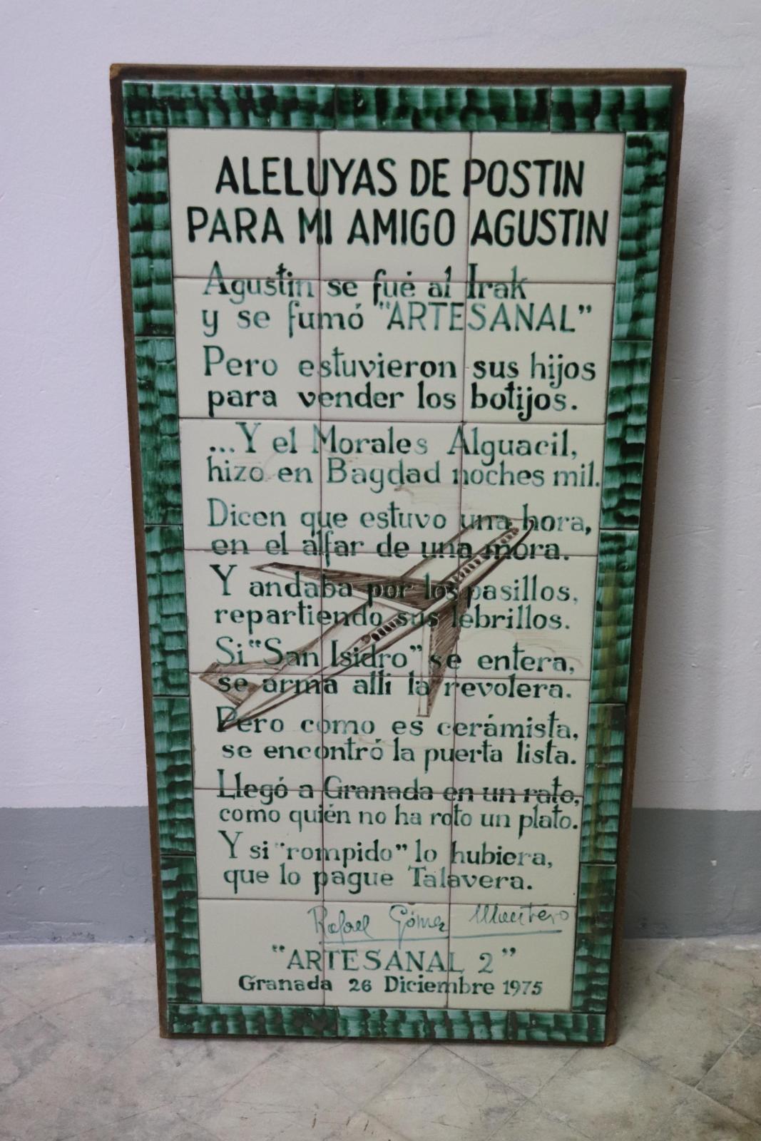 Paño de azulejos blancos con decoración verde y marrón, enmarcado por piezas longitudinales verdes