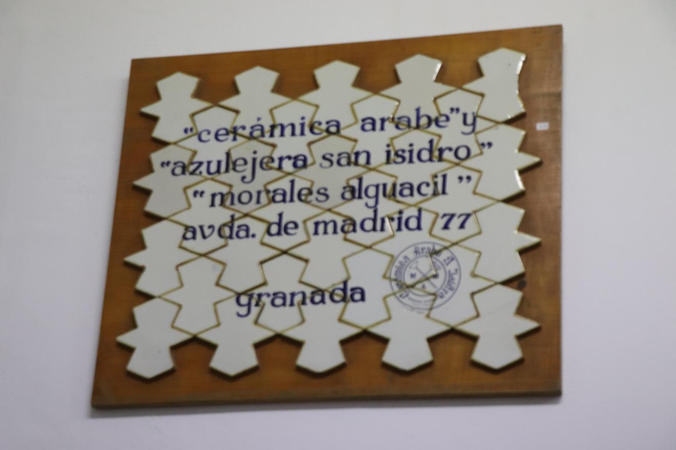 Paño de azulejos de original geometría, con texto en azul cobalto, adheridos a una plancha de madera