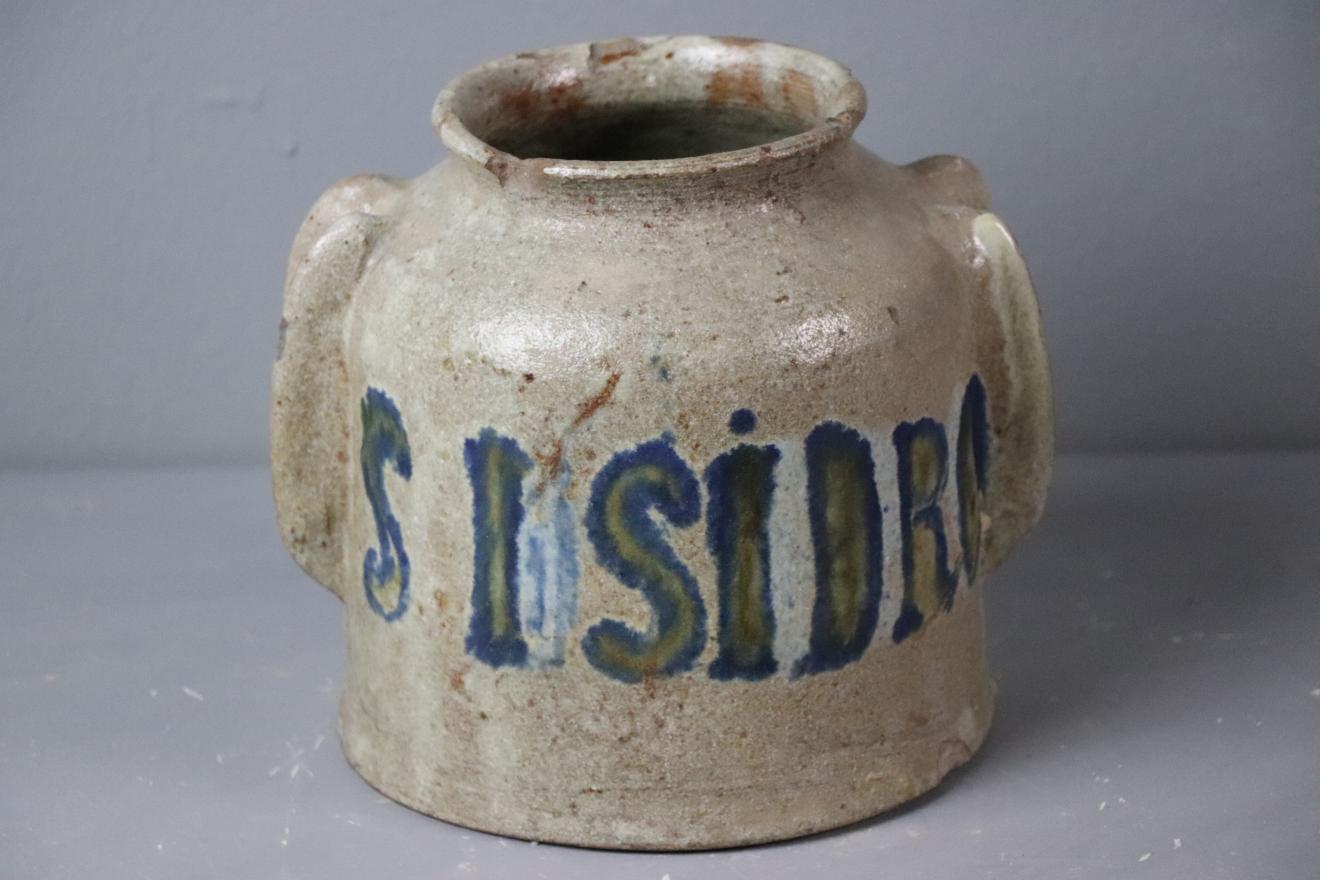 Tarro de cerámica esmaltado en blanco con inscripción "S. Isidro" en azul y verde