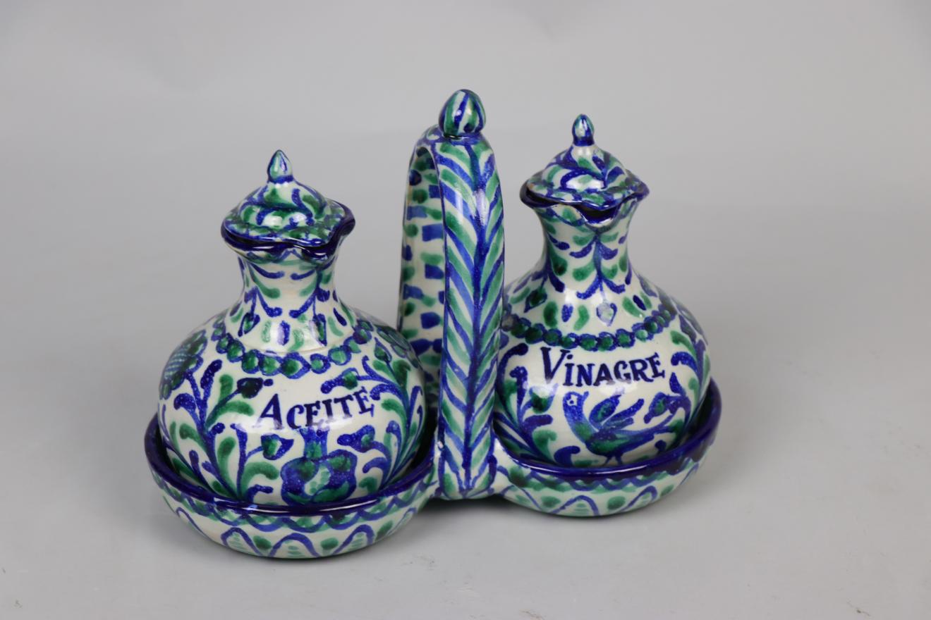 Aceitera y vinagrera de cerámica granadina sobre soporte doble con asa central. Ambas decoradas con policromía en blanco, azul y verde