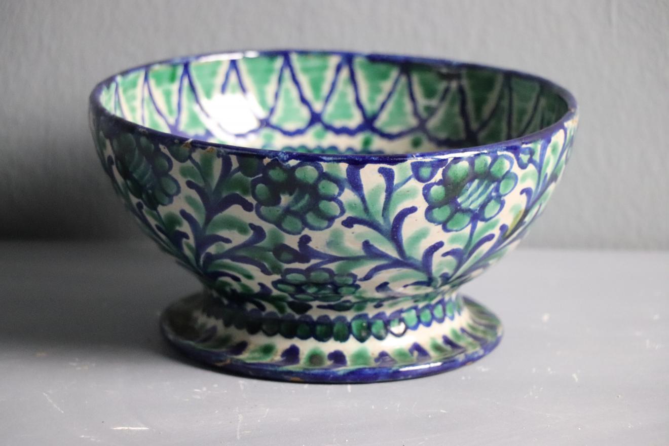 Frutero de cerámica granadina con decoración verde y azul sobre fondo blanco