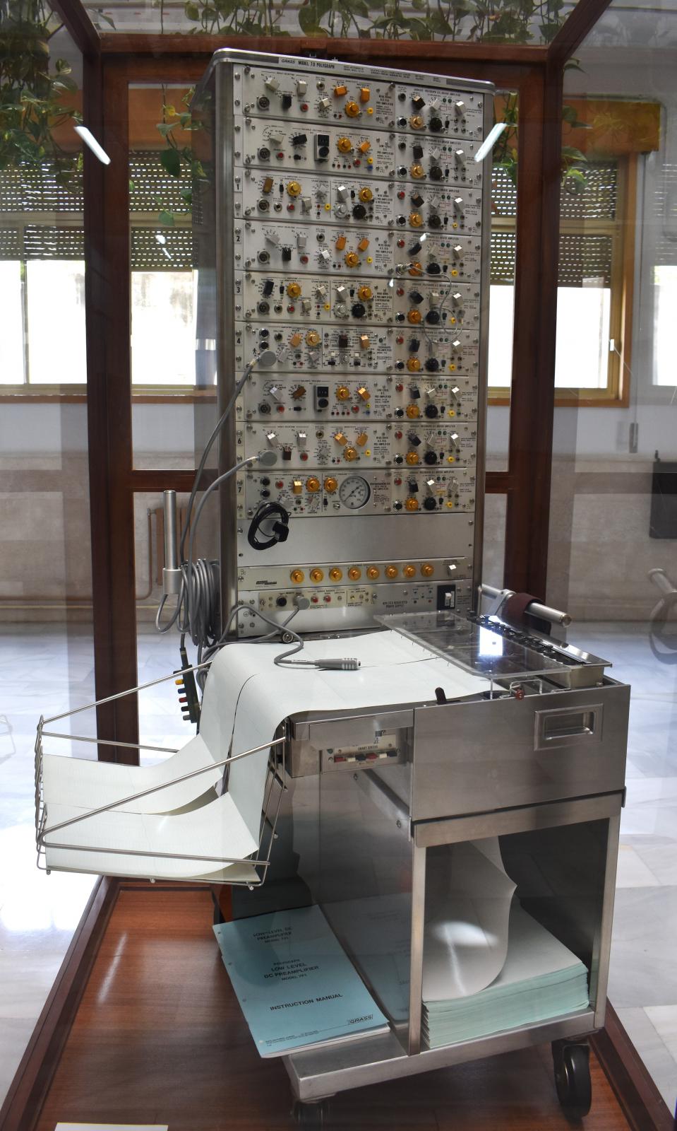 imagen frontal de un poligrafo, una maquina de gran altura que dispone de dos cintas de papel. 