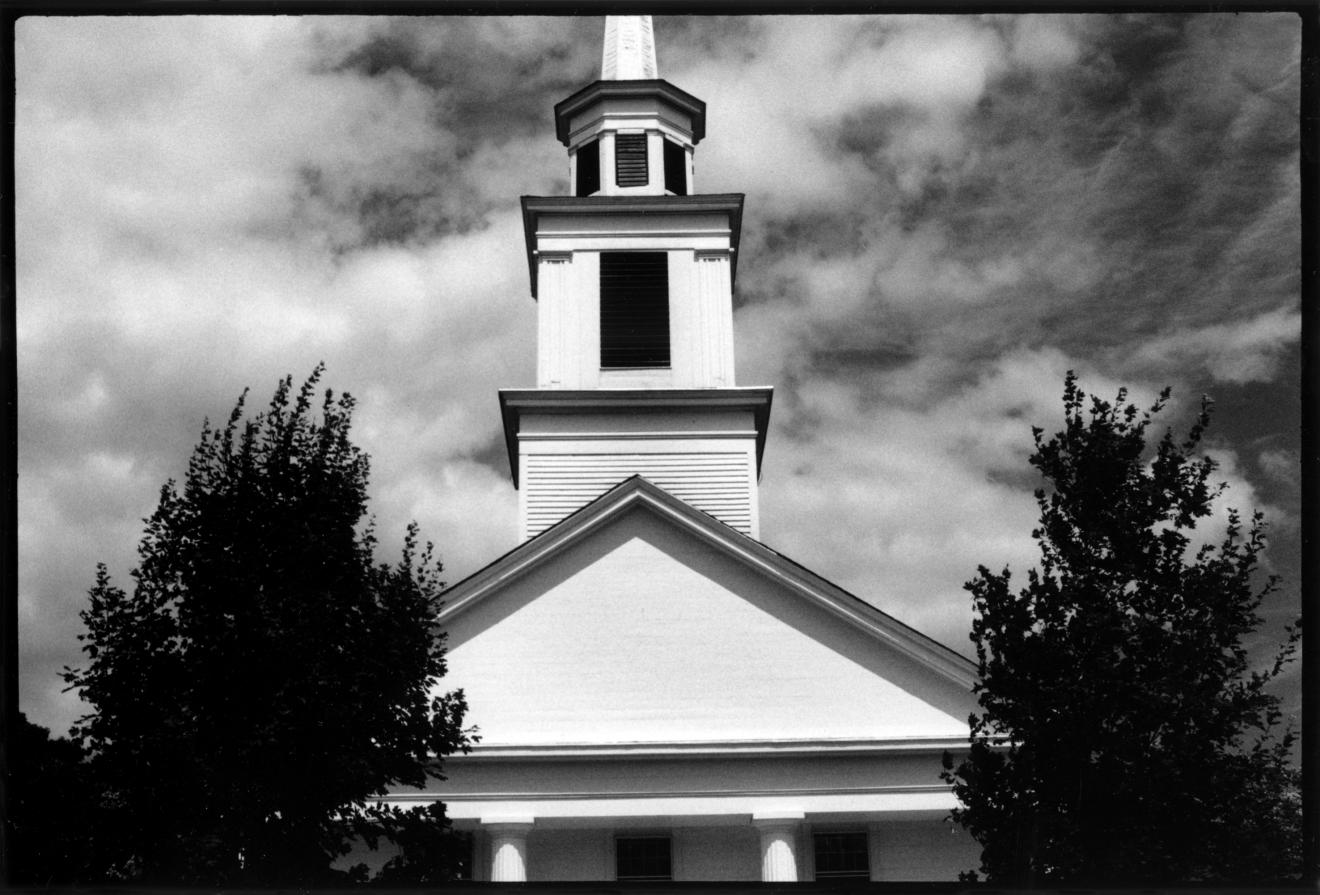 Fotografía en blanco y negro de la torre y el frontón de un edificio